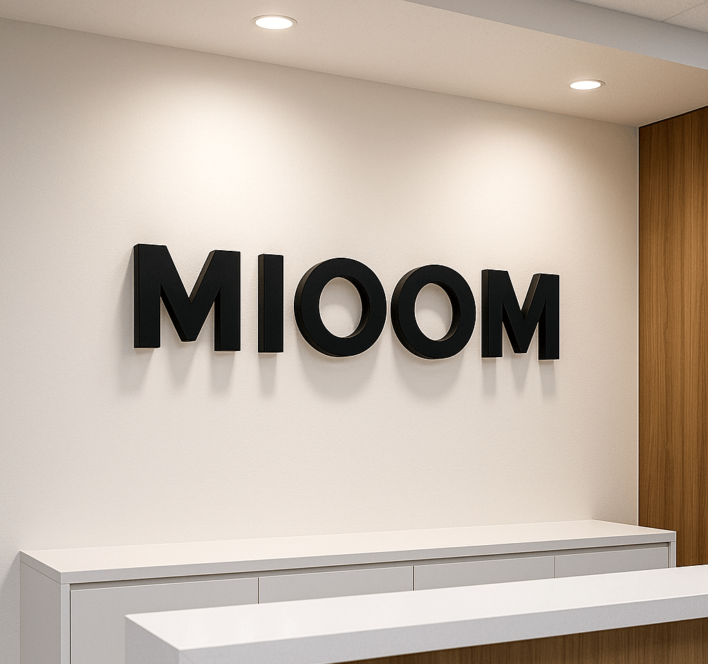 白い受付壁に30mm厚の立体ロゴを設置したオフィスエントランスの写真